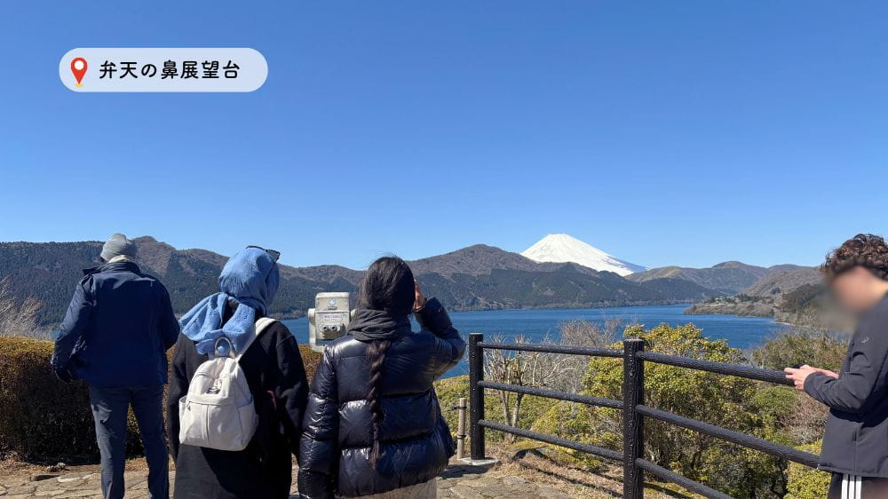 山の風景を高台から見る人。