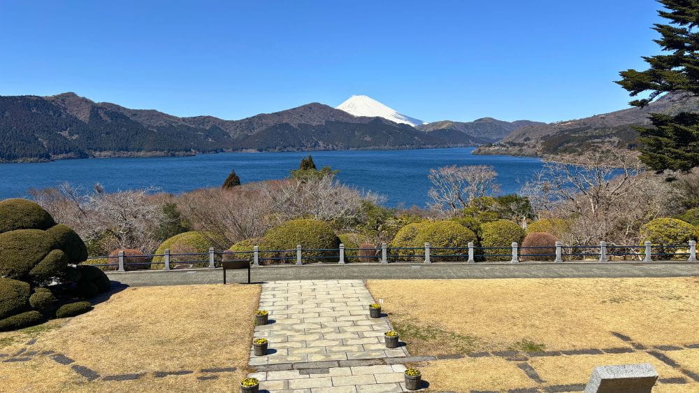 白と緑の山と湖。手前には整地された庭。