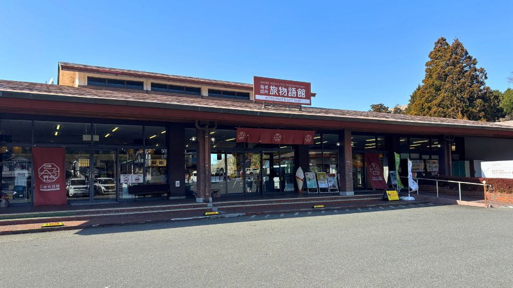 茶色の看板と垂れ幕がかかった横長の建物