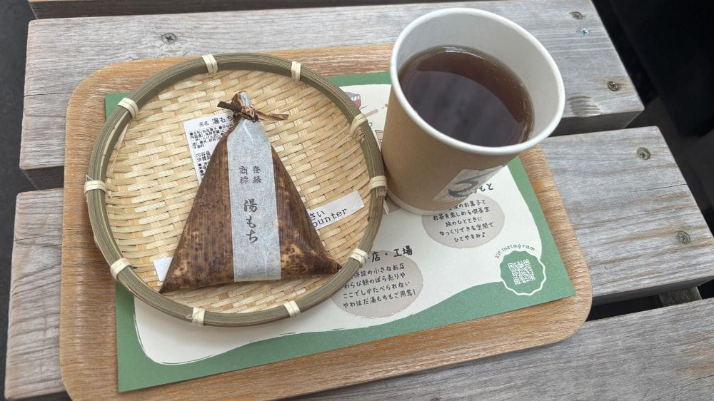 ちもとの茶店でいただく湯もちとお茶のセットをトレーにのせた様子