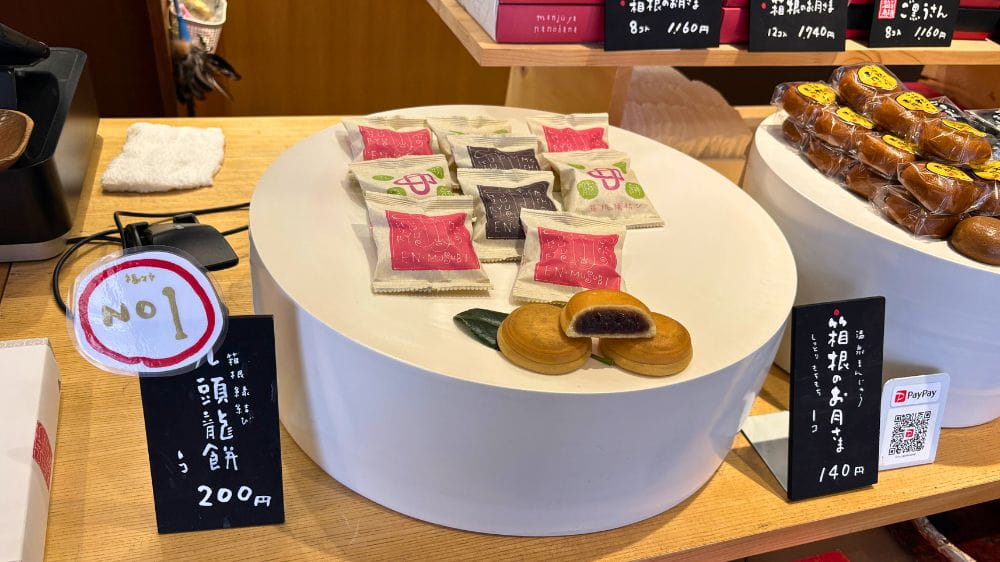 箱根湯本の九頭龍餅店内に並ぶ焼きまんじゅうとお土産用商品のディスプレイ