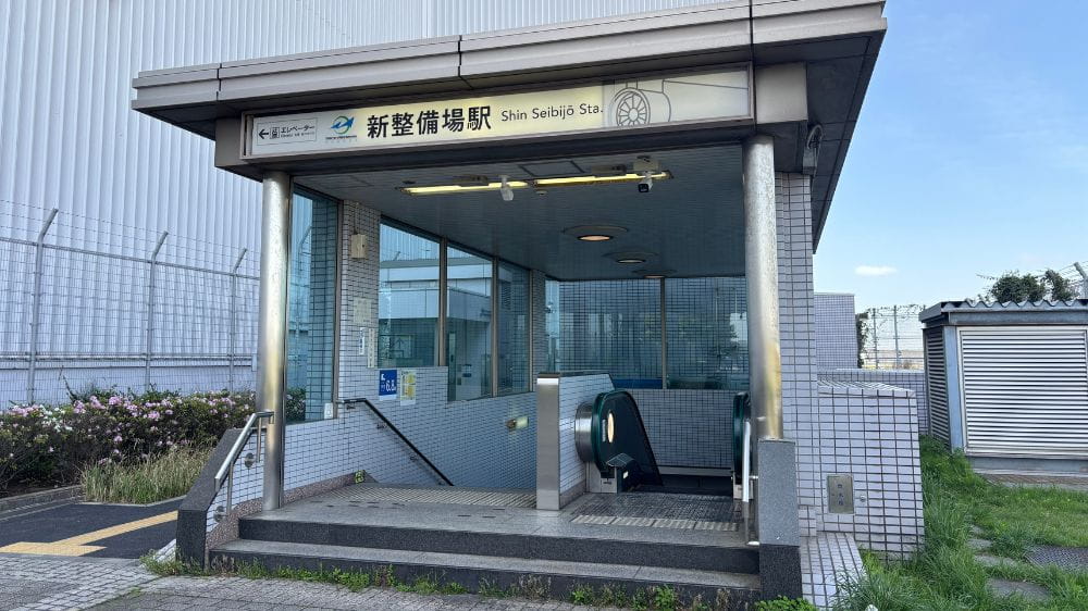 新整備場駅の出入口とエスカレーターがある駅構内の様子。