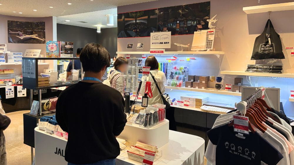 JALスカイミュージアムの売店で航空関連グッズやお土産を選ぶ来場者の様子。