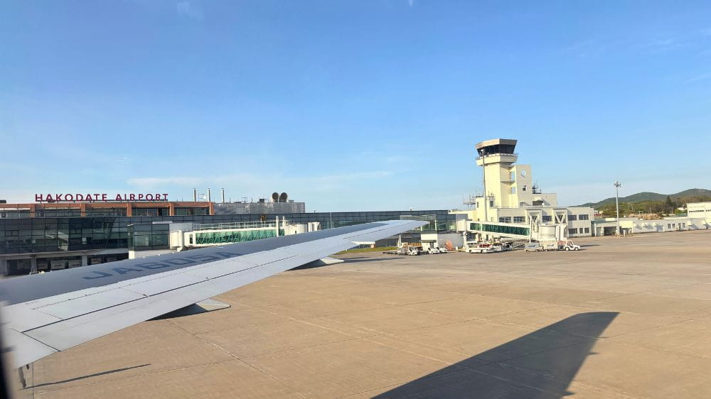 飛行機の窓から見た函館空港の滑走路とターミナル