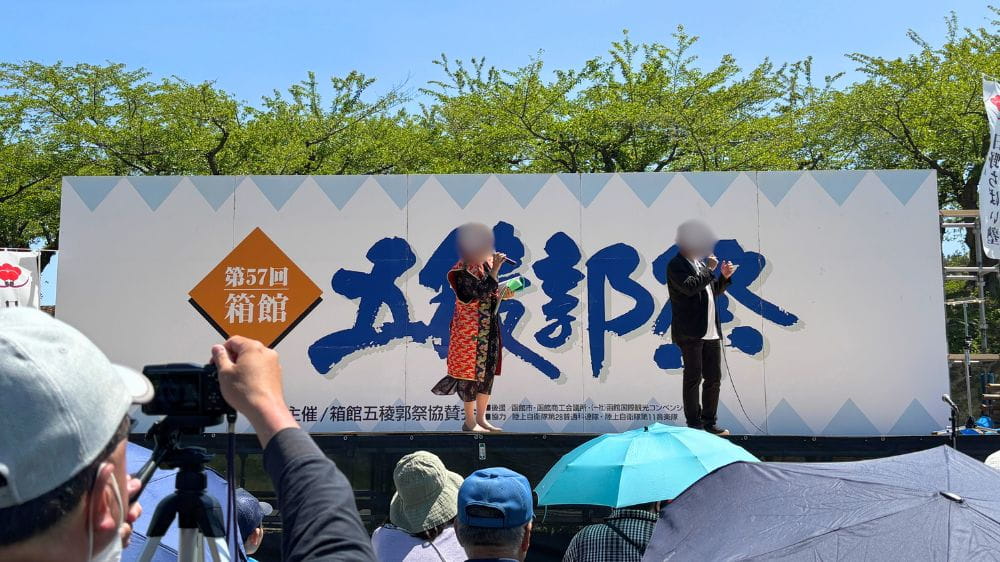 五稜郭祭ステージで来場者に向けて進行する司会者
