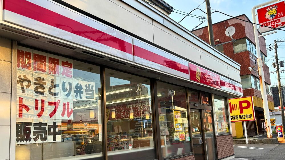 函館市にあるハセガワストア五稜郭店の外観。窓に「期間限定 やきとり弁当トリプル販売中」の案内が掲示されている。