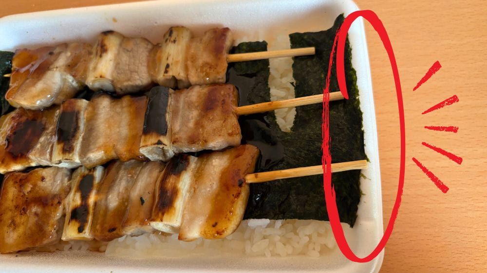 ハセガワストア五稜郭店で購入したやきとり弁当。串を抜くための容器右側の溝を赤丸で示している