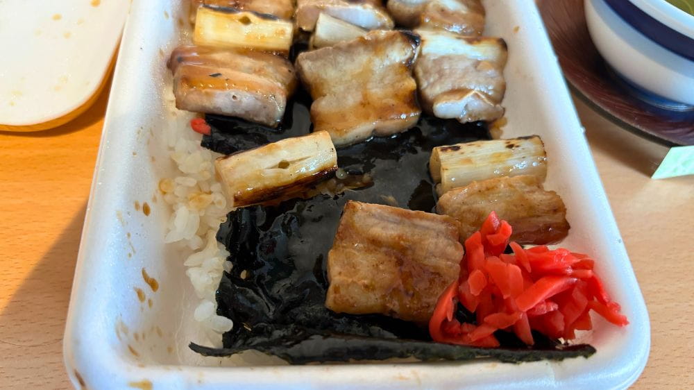 ハセガワストア五稜郭店で購入したやきとり弁当(小・タレ)のアップ。タレをまとった豚肉と長ねぎ、のり、ご飯、紅しょうがが見える