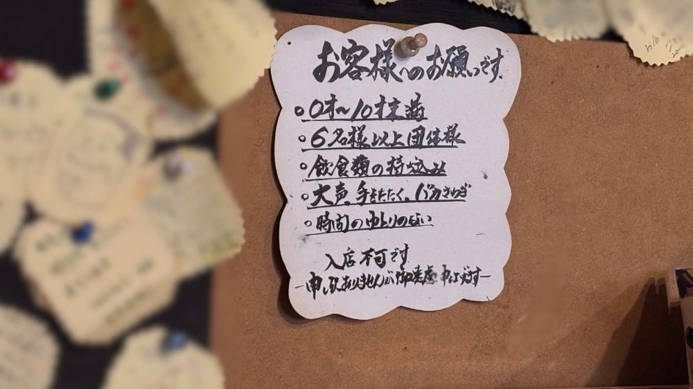 日本の喫茶店の壁に貼られた、入店ルールを案内する手書きの注意書き。
