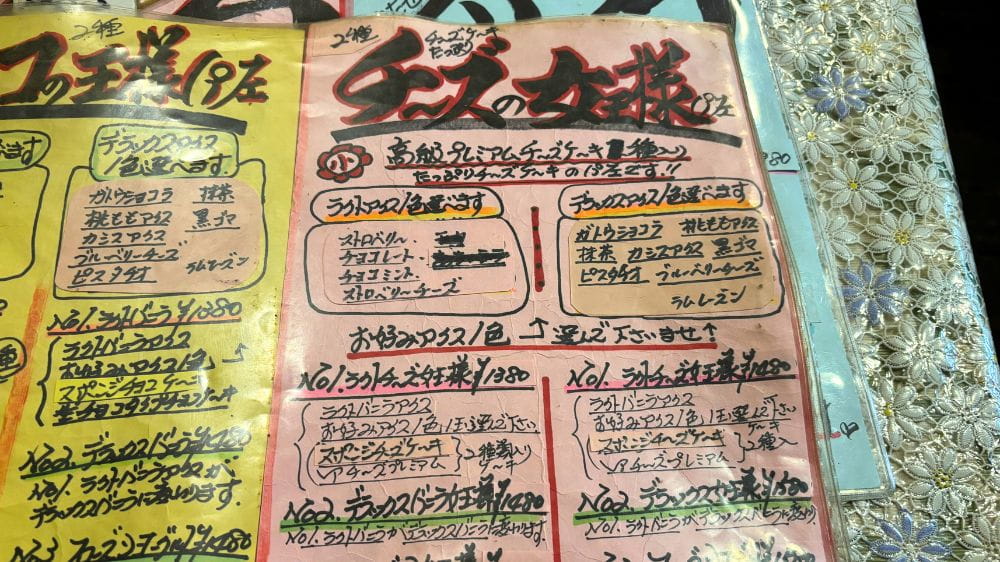喫茶のんのんのチーズケーキパフェメニュー。チーズケーキやチーズを使ったパフェの種類やトッピングが掲載された手書きメニュー。