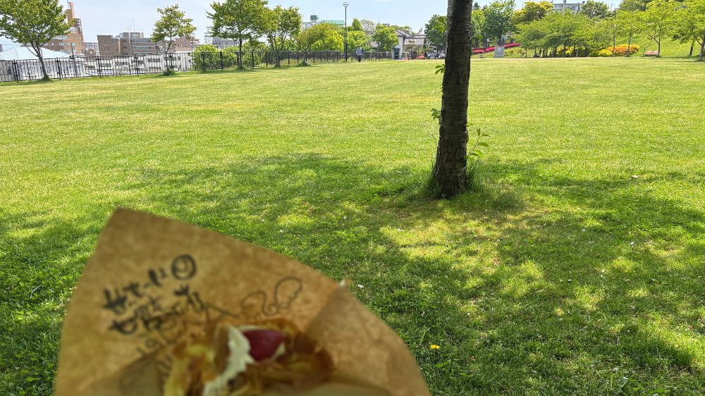 函館・ペリー広場の芝生を背景に持つアンジェリック・ヴォヤージュのクレープ