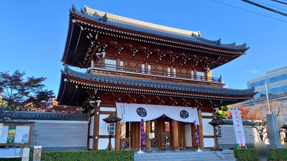 青空の下に建つ寺院の門を写した史跡巡りの写真