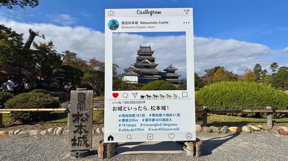 松本城の本丸庭園に設置されたInstagram投稿風の撮影パネルと、枠内に見える天守